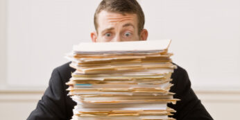 Businessman Behind Stack of File Folders